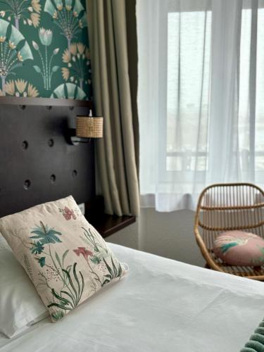 a bedroom with a bed with a pillow and a chair at Ambassadeur Hotel - Cherbourg Port de Plaisance in Cherbourg en Cotentin