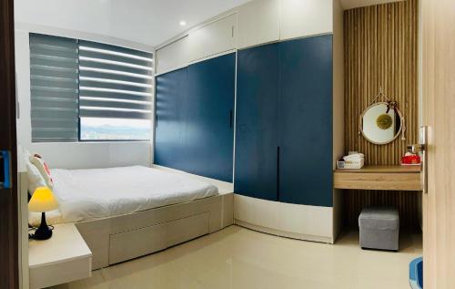 a bedroom with a bed and a blue wall at Chi Homestay Nera Garden Huế in Hue