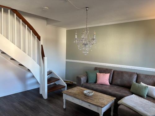 a living room with a couch and a chandelier at Ferienwohnung Heimatglück 2-3 Personen 65qm WLAN in Breitbrunn am Chiemsee