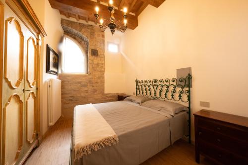 a bedroom with a bed and a chandelier at Elena - CASA VACANZE BALDASSINI N 15 in Gubbio