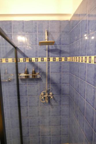 a blue tiled bathroom with a shower with a shower at Embassy Suites in Colombo