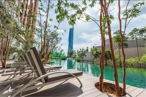 um par de espreguiçadeiras ao lado de uma piscina em Seabreeze 1BR Suite with Gorgeous Infinity Pool em Kuala Lumpur