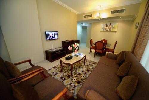 a living room with a couch and a table at Emirates Stars Hotel Apartments Sharjah in Sharjah