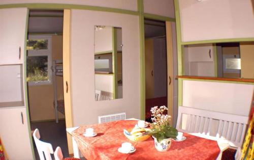 a dining room with a table with a vase of flowers at Villaggio Colombo NUOVA GESTIONE in Marina dʼAndora