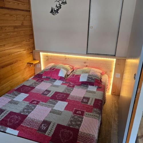 une chambre avec un lit avec une couette dessus dans l'établissement Valmeinier 1800 Ecrin des Neiges, à Valmeinier