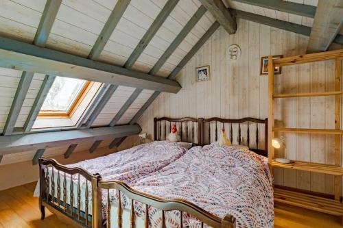 ein Schlafzimmer mit einem Bett auf einem Dachboden in der Unterkunft Villa charmante à Beynac-et-Cazenac avec piscine privée in Beynac-et-Cazenac