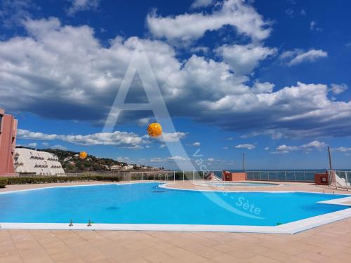 - une piscine avec deux balles dans le ciel dans l'établissement CAP CORNICHE piscine, studio cabine 4 personnes clim, wifi et parking, à Sète