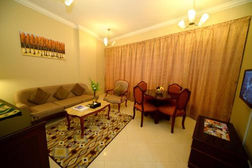 a living room with a couch and a table at Emirates Stars Hotel Apartments Sharjah in Sharjah