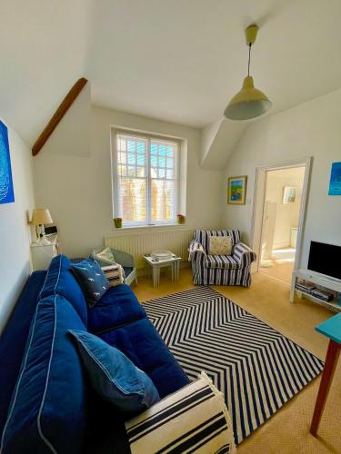 a living room with a blue couch and a rug at Lyme Regis renovated period seaside flat in Lyme Regis