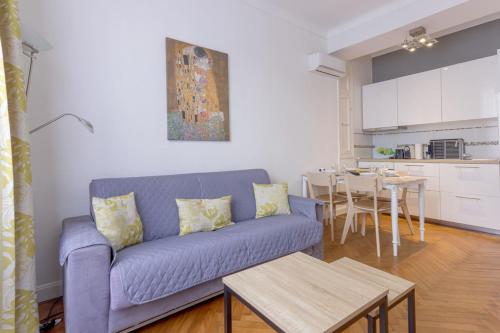 un salon avec un canapé bleu et une cuisine dans l'établissement Nice flat in the heart of Cannes, à Cannes
