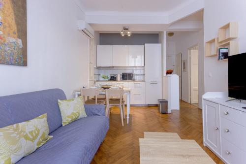un salon avec un canapé bleu et une cuisine dans l'établissement Nice flat in the heart of Cannes, à Cannes