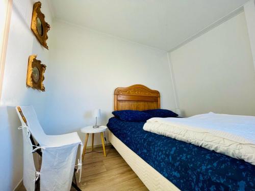 ein Schlafzimmer mit einem Bett, einem Tisch und einem Stuhl in der Unterkunft Liguster 84* in Nieuwvliet