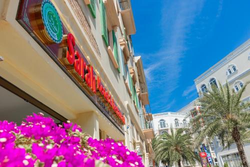 a building with pink flowers in front of it at Sarah Hotel Halal Restaurant Phu Quoc in Phu Quoc