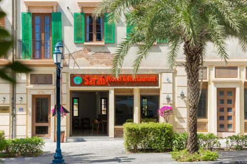 a building with a palm tree in front of it at Sarah Hotel Halal Restaurant Phu Quoc in Phu Quoc