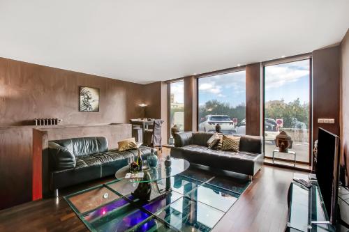 un salon avec un canapé et une table en verre dans l'établissement Apartment With Sauna At Border Of Monaco, à Beausoleil