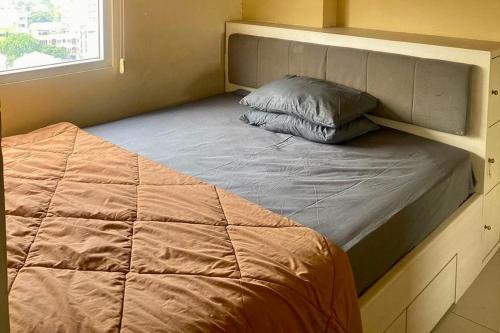 a bed in a small room with a bed frame at Green Pramuka by Uchi Property in Jakarta