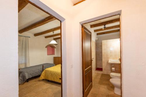 a bathroom with a bed and a toilet in a room at Montepozzalino in Massa Marittima