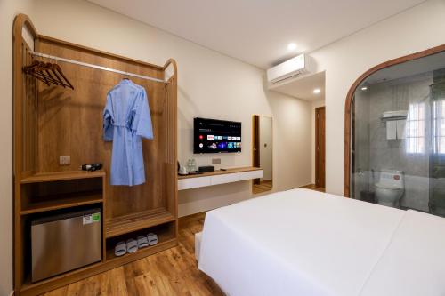 a hotel room with a bed and a blue robe at Sarah Hotel Halal Restaurant Phu Quoc in Phu Quoc