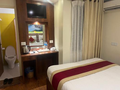 a hotel room with a bed and a toilet at Hotel Friends Home in Kathmandu