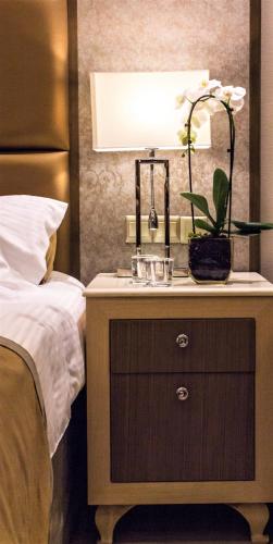 a nightstand with a lamp on it next to a bed at Adams Beach Hotel & Spa in Ayia Napa