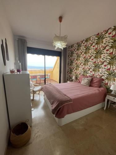 a bedroom with a large bed with a large window at Penthouse 6-8 personnes in Manilva
