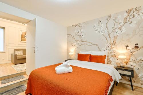 une chambre avec un grand lit avec une couverture orange dans l'établissement GuestReady - Charming Parisian stay in Salpêtrière, à Paris