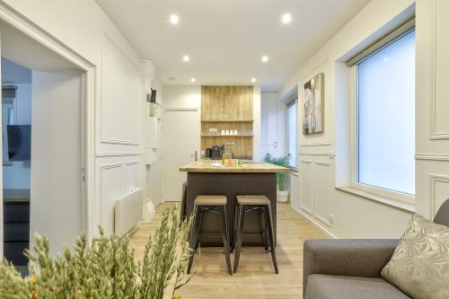 une cuisine avec un comptoir et des tabourets dans une pièce dans l'établissement GuestReady - Charming Parisian stay in Salpêtrière, à Paris