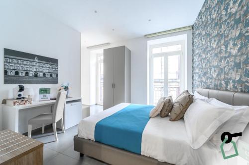 ナポリにあるHOTIDAY Room Collection - Napoli Centro Storicoのベッドと机とテーブルのある寝室