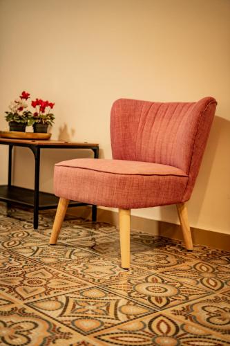 a chair in a room with a table and flowers at ΣΟΧΟΣ ΠΑΡΑΔΟΣΙΑΚΕΣ ΟΙΚΙΕΣ - Σαχνισί in Zokhós