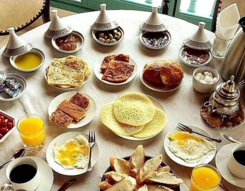 a table topped with plates of breakfast foods and drinks at Natural Farming in Sidi Bibi