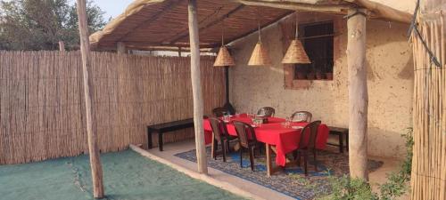 a red table and chairs under a pergola at Natural Farming in Sidi Bibi