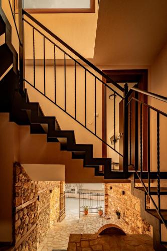 a staircase in a house with a stone wall at ΣΟΧΟΣ ΠΑΡΑΔΟΣΙΑΚΕΣ ΟΙΚΙΕΣ - Σαχνισί in Zokhós