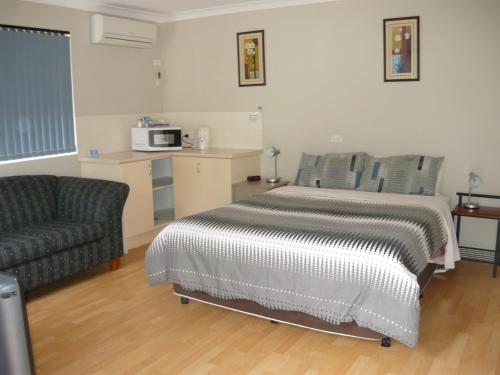 a bedroom with a bed and a couch and a microwave at Albany Apartments in Albany