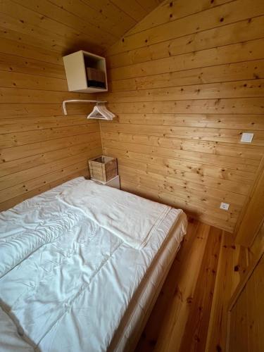 a bedroom with a bed in a wooden room at 108 - Tiny House mit Blick ins Grüne in Bleckede