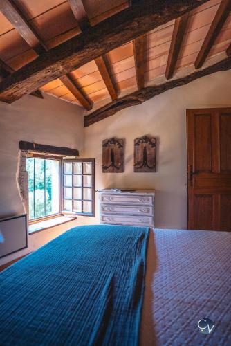 une chambre avec un lit bleu et une fenêtre dans l'établissement Studio 2, à Saint-Montan