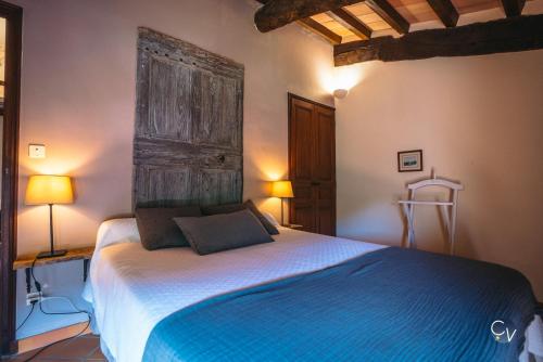 une chambre avec un lit avec une grande tête de lit en bois dans l'établissement Studio 2, à Saint-Montan