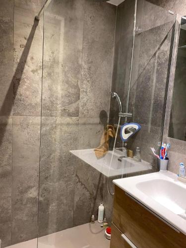 une douche avec une porte vitrée à côté d'un lavabo dans l'établissement Appartement 500m de la plage, à Sainte-Maxime