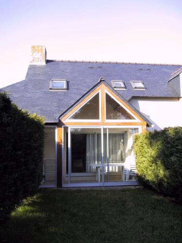 une véranda avec une table et des chaises dans une maison dans l'établissement REF 080 Maison pour quatre personnes avec garage Arzon, à Arzon