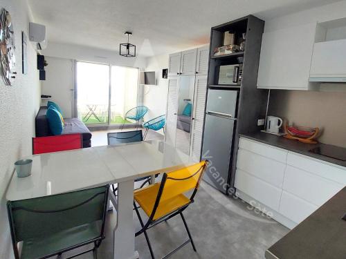 une cuisine avec une table et des chaises jaunes dans une pièce dans l'établissement T2 4 personnes avec balcon vue mer tout equipe, à Sète