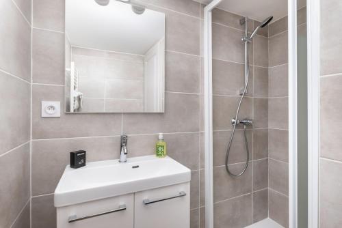 リヨンにあるAppartement vue sur la Saôneのシャワーと白い洗面台を備えたバスルーム