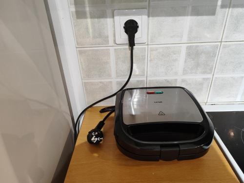 a black appliance sitting on a table with a cord at S & K GROUND FLAT in Vrilissia in Athens