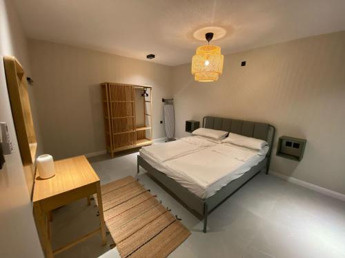 a bedroom with a bed and a table and a lamp at Al Salehiyah 2 in Medina