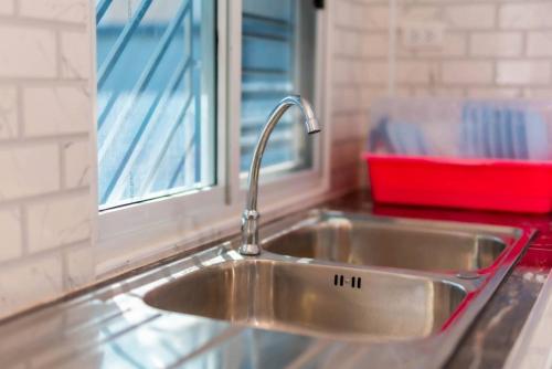 a stainless steel sink in a kitchen with a window at Wanna house บุรีรัมย์ ใกล้สนามช้างอารีน่า in Buriram