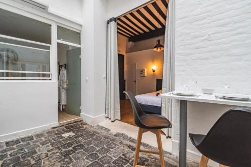 une pièce avec une table et des chaises et une chambre dans l'établissement Steam - Baignoire balnéo et clim, à Reims