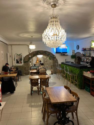 un restaurant avec des tables, des chaises et un lustre dans l'établissement Café du Commerce, à Génolhac