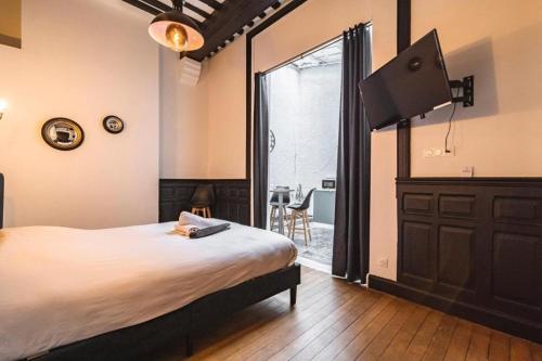 une chambre avec un grand lit et une grande fenêtre dans l'établissement Steam - Baignoire balnéo et clim, à Reims