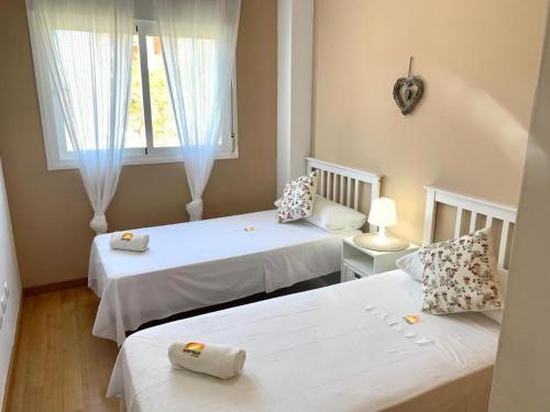 une chambre avec deux lits et une fenêtre dans l'établissement Apartamento Novomar By Solymar Holiday, à Torre del Mar