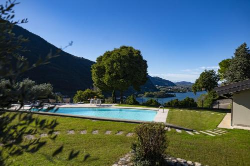 a swimming pool in a yard with a lake at Villa Anna Lake View in Pilzone