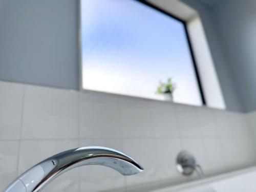 a bathroom sink with a mirror and a faucet at Spacious Comfty 4 BDMs House in Rototuna in Hamilton