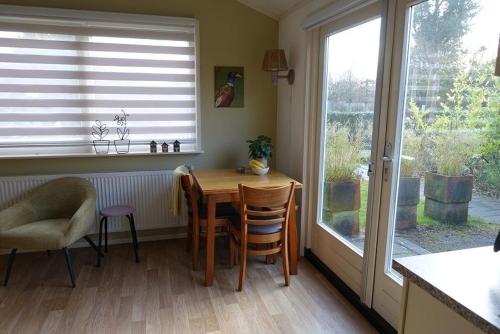 a kitchen with a table and chairs and a window at Rekerlanden 257 in Schoorldam